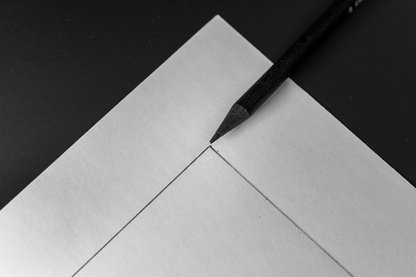 Close-up van potloodpunt die raakpunt van twee lijnen op papier markeert nauwkeurigheid tekenen h2 neem contact op